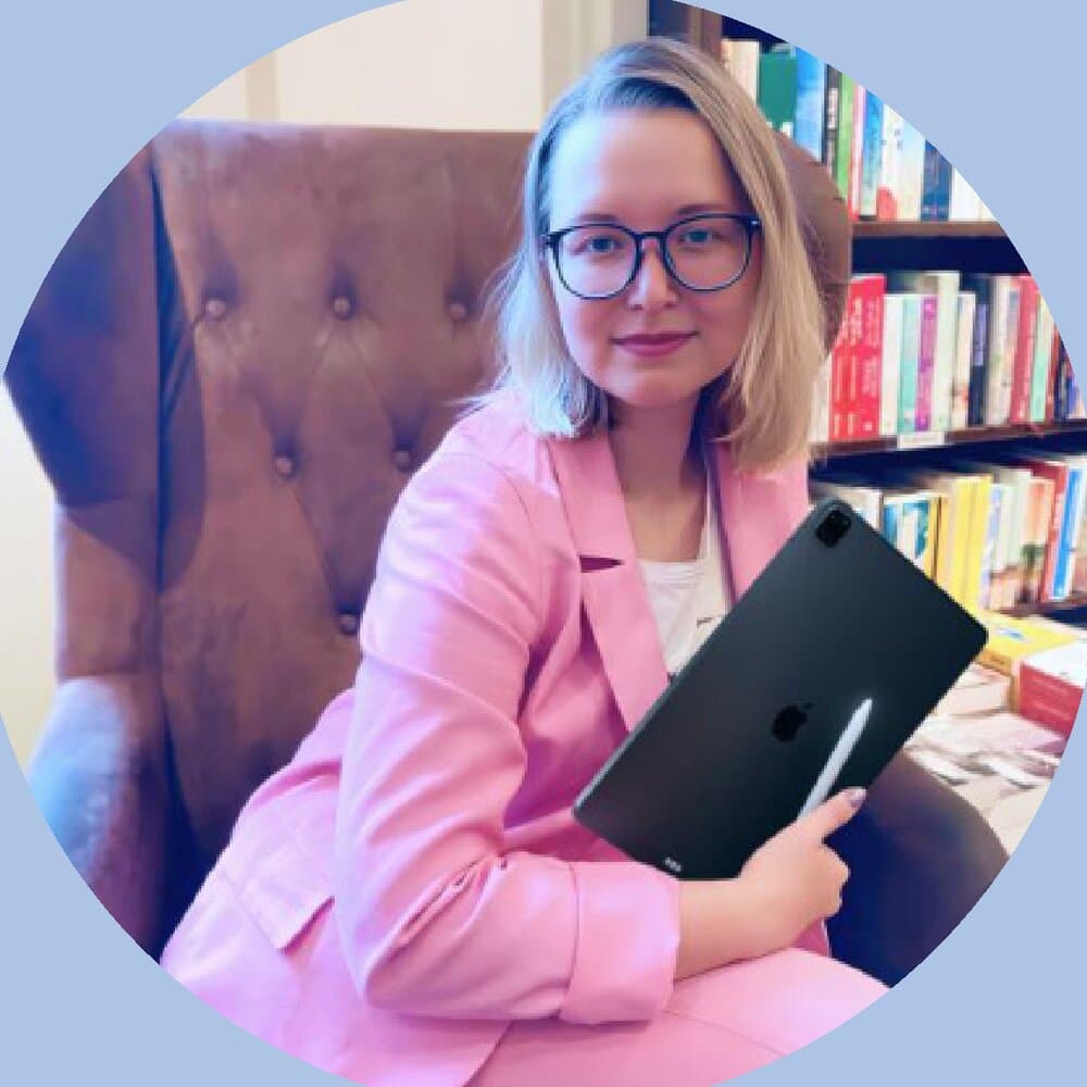 Viktoria Lukianov in einem Sessel vor einem Bücherregal, mit Tablet und Stift