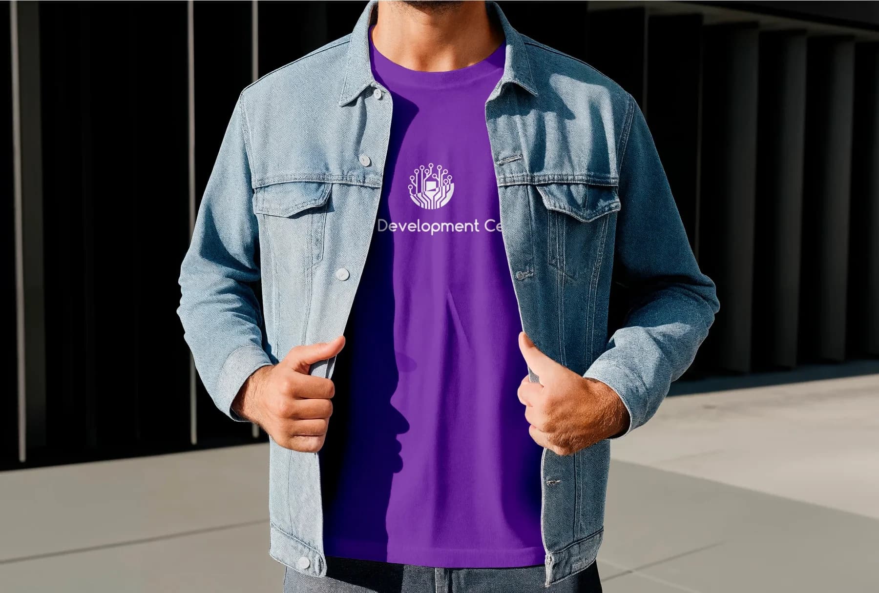 Mann in Jeansjacke mit violettem T-Shirt mit Logo