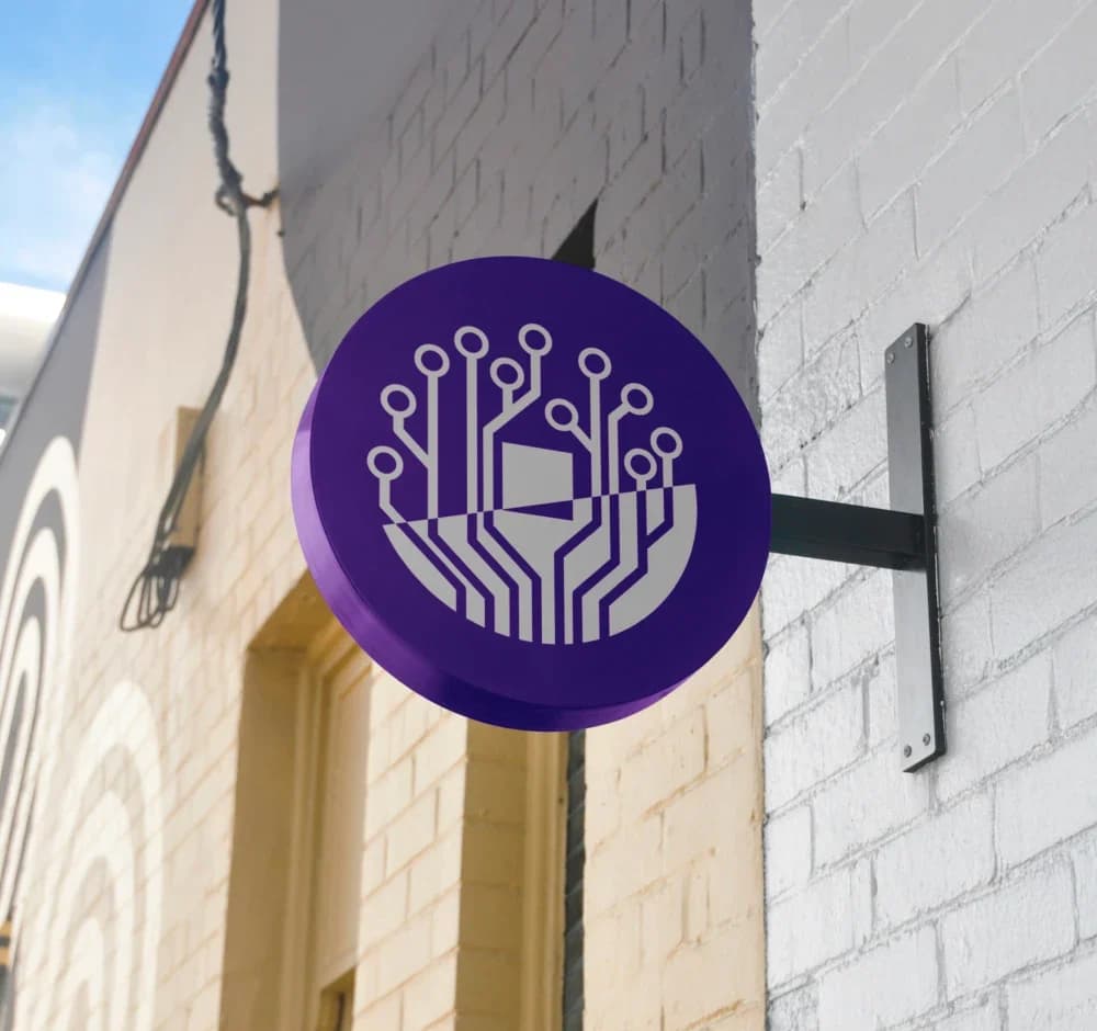 Rundes violettes Ausleger-Schild mit der Bildmarke an einer Hauswand