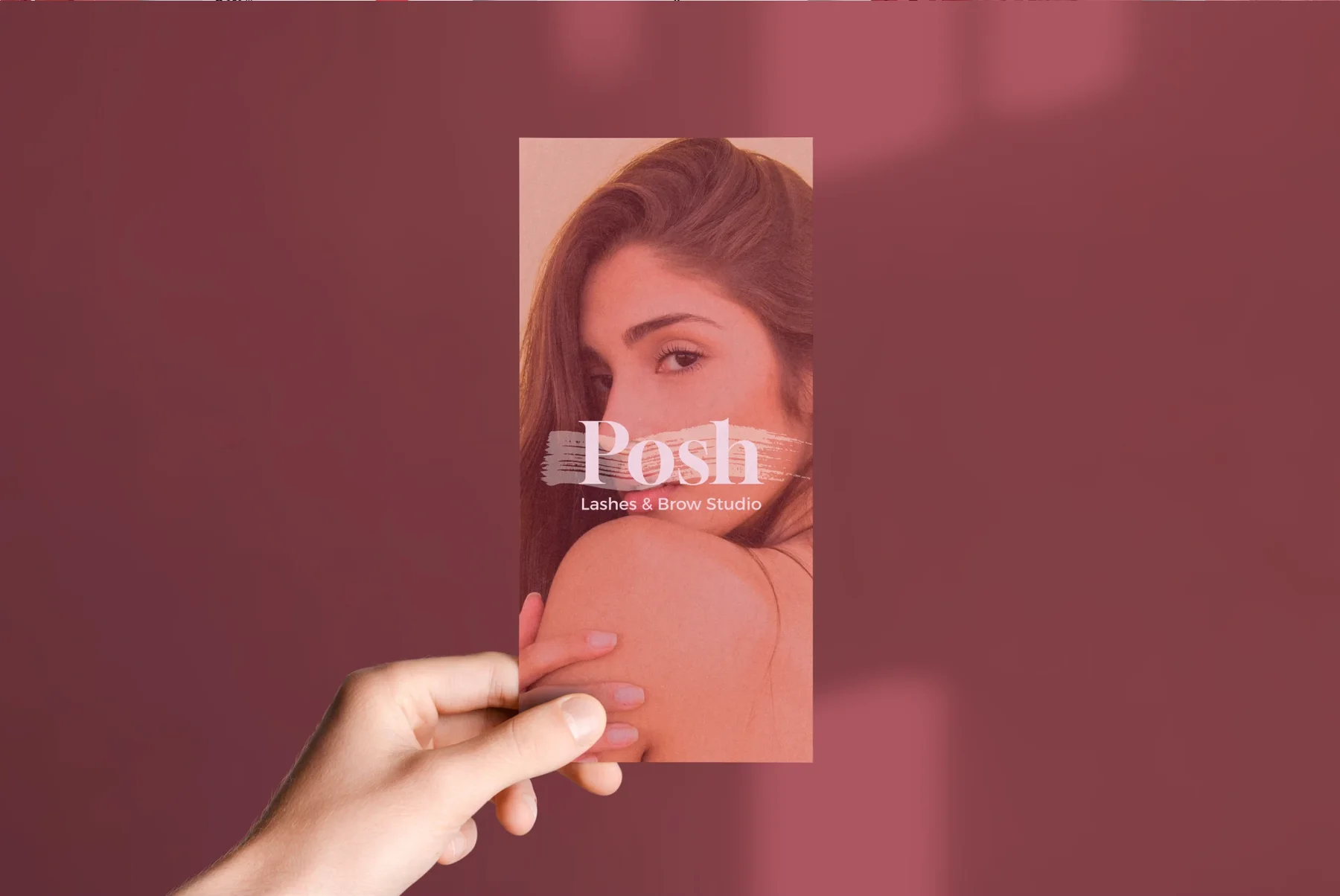 Eine Hand hält eine Karte mit Porträt und Posh-Logo vor beerenfarbenem Hintergrund
