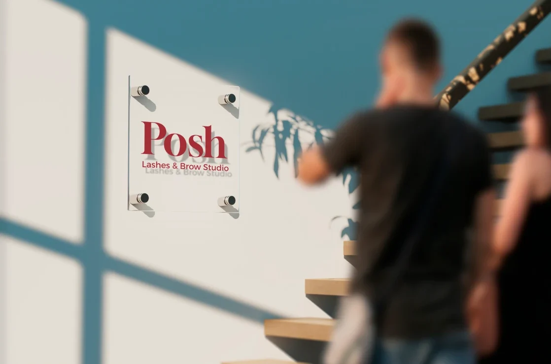 Wandschild mit Posh-Logo im Studio, davor zwei Personen